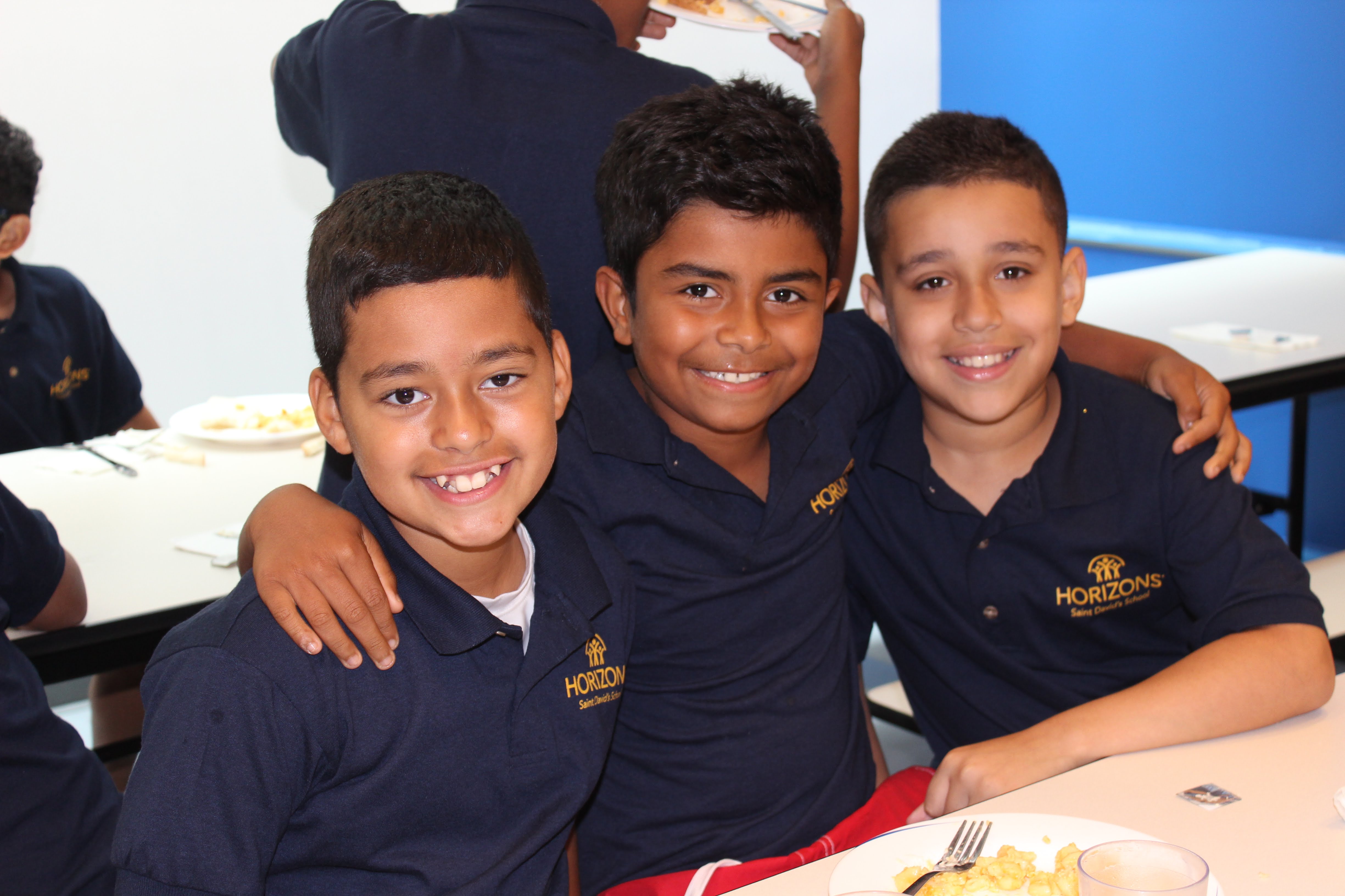 Three smiling boys wearing blue Horizons program shirts